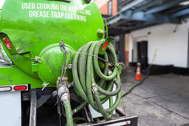 a service truck pumping grease from a restaurant's grease trap in Belmont