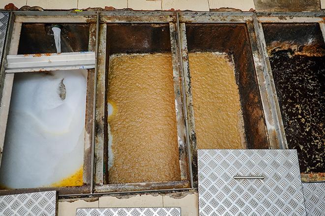 skilled technician cleaning out a commercial grease trap